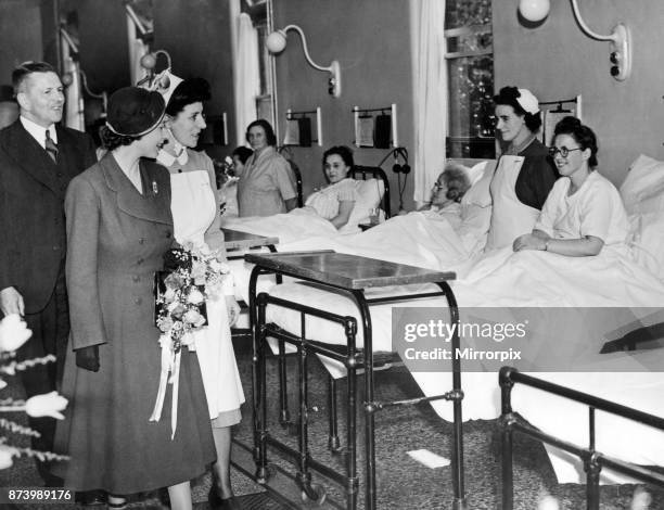 Princess Elizabeth visiting the West Midlands. She smiles encouragingly at patients as she walks through a women's ward at Selly Oak Hospital. May...