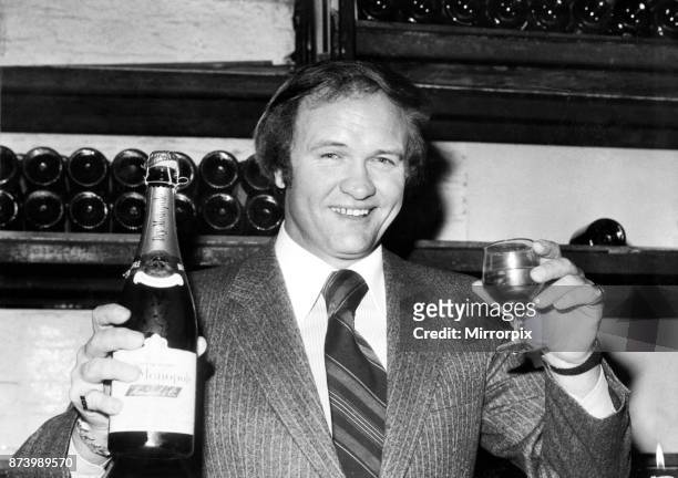 West Bromwich Albion football manager Ron Atkinson holds up a bottle of champagne at the Cheshire Cheese restaurant in Fleet Street, London as he...