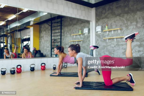 junge sportliche frauen bein und po übungen - leg stretch girl stock-fotos und bilder