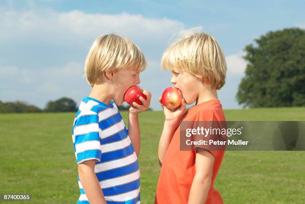 мальчик угощает другого яблоком
