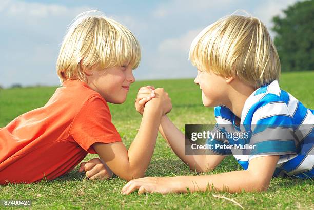 two boys arm wrestling - sibling rivalry stock pictures, royalty-free photos & images