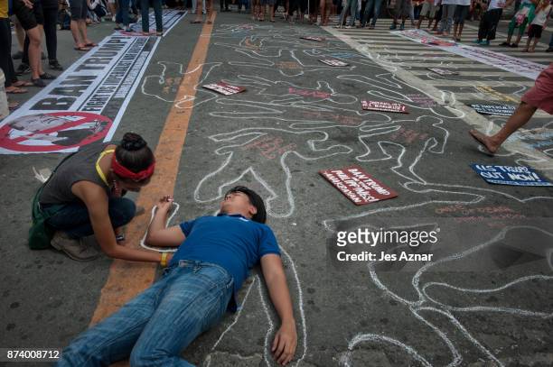 Protesters draw chalk outlines mimicking the thousands of killings happening under the Duterte presidency on November 14, 2017 in Manila,...