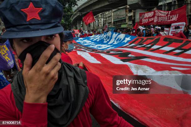 Protesters march on the streets and carry a US flag to burn as protest to US President Trump's visit in the Philippines on November 14, 2017 in...