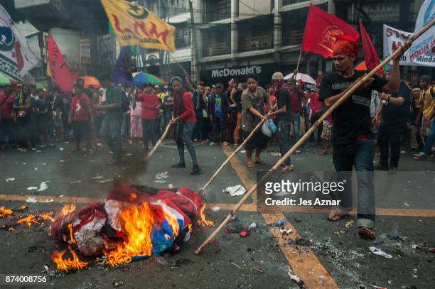 Protesters burn a US flag to protest US President Trump's visit in the Philippines on November 14, 2017 in Manila, Philippines. Hundreds of Filipinos...