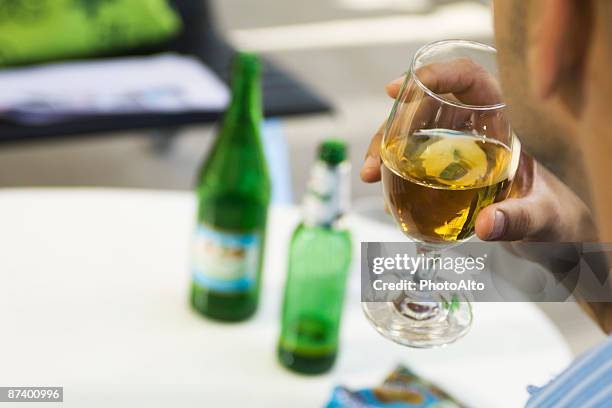 man drinking beer from a glass, cropped, over the shoulder view - hands behind glass stock pictures, royalty-free photos & images