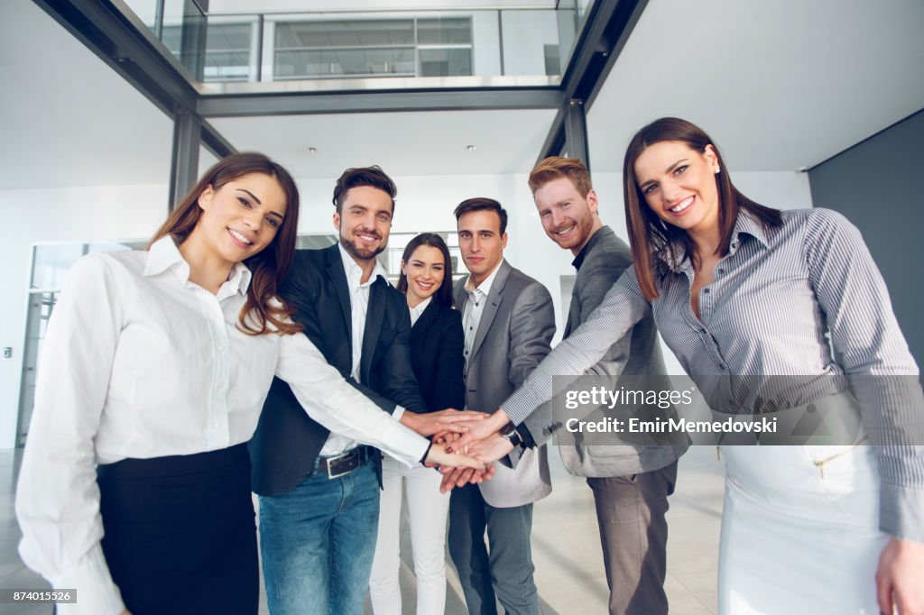 Business team joining hands in a huddle