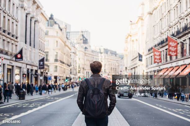 tourist with backpack walking on regent street in london, uk - london tourist stock pictures, royalty-free photos & images