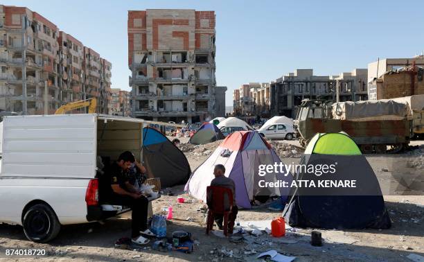 Iranians camp in tents outside near damaged buildings in the town of Sarpol-e Zahab in the western Kermanshah province near the border with Iraq, on...