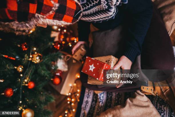 close up of a man holding mas gifts in front of the tree - party under stock pictures, royalty-free photos & images