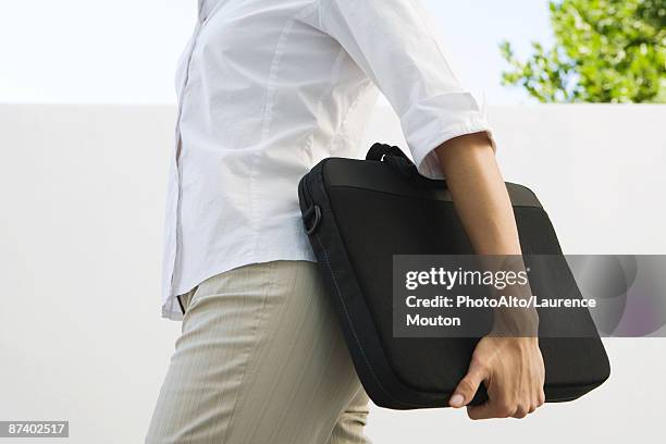 woman carrying laptop bag, cropped view of mid section - maletín para portátil fotografías e imágenes de stock