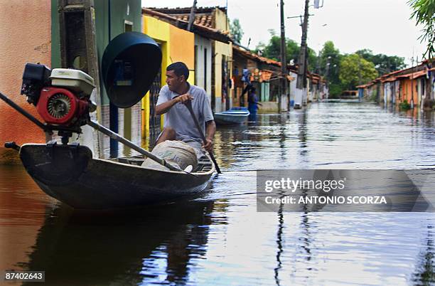 Man rows a canoe in a street flooded by the Mearim river in Bacabal, in the state of Maranhao, northern Brazil, on May 15, 2009. Around a million...