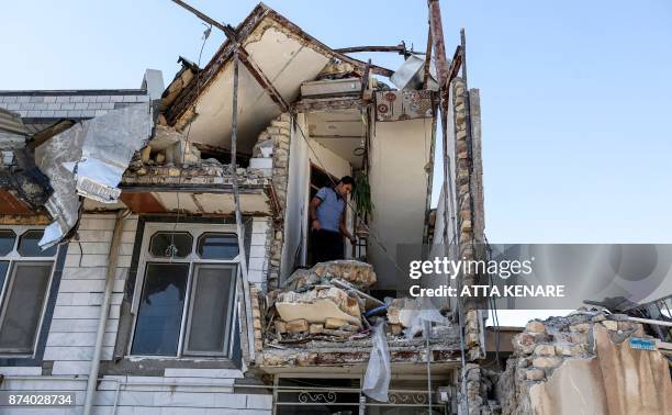 An Iranian man looks through the damaged stairwell of a building in the town of Sarpol-e Zahab in the western Kermanshah province near the border...