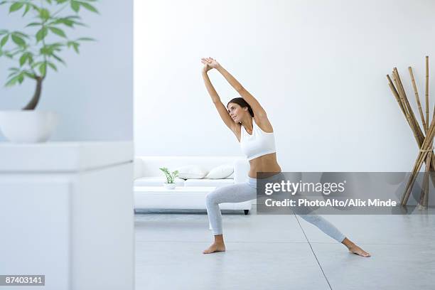 woman performing yoga pose in living room - armpit hair woman stock pictures, royalty-free photos & images