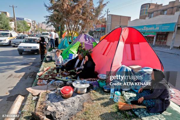 Iranians camp in tents and make-shift shelters outside near damaged buildings in the town of Sarpol-e Zahab in the western Kermanshah province near...