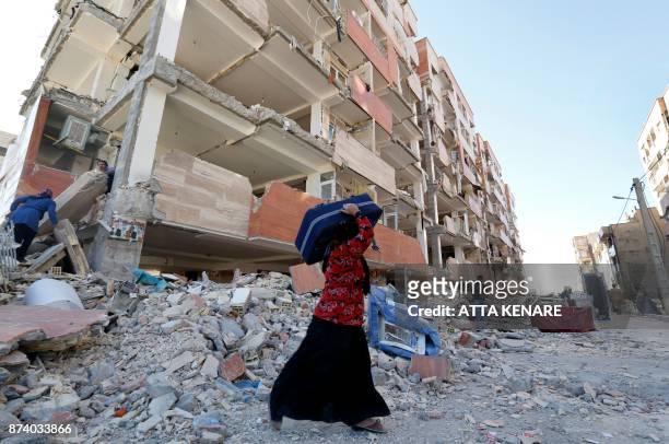 Iranians salvage items from damaged buildings in the town of Sarpol-e Zahab in the western Kermanshah province near the border with Iraq, on November...