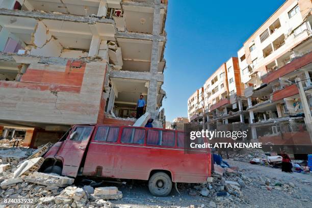 Iranians salvage items from damaged buildings in the town of Sarpol-e Zahab in the western Kermanshah province near the border with Iraq, on November...