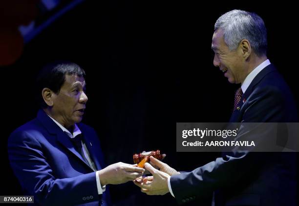 Philippine President Rodrigo Duterte hands over the gavel to Singapore Prime Minister Lee Hsien Loong during a transfer of ASEAN Chairmanship at the...