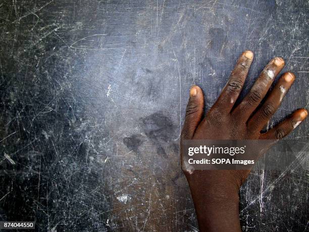 Child's hand pictured as he cleans the classroom's blackboard. Perhaps the people of South Sudan suffer the most on Earth. Decades of fight,...