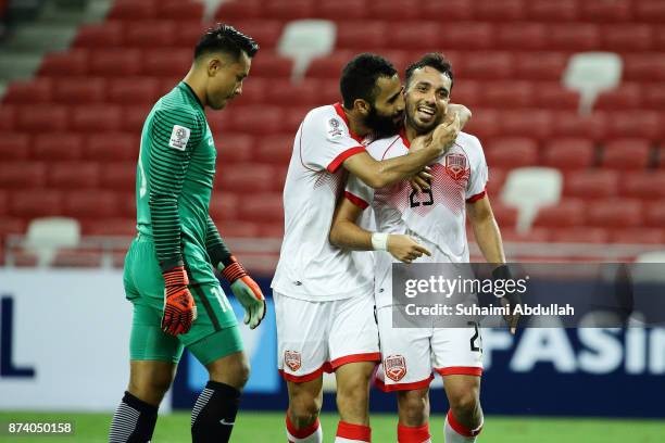Mahdi Abdul Jabbar congratulates Jamal Rashed of Bahrain after scoring the second goal as Hassan Sunny of Singapore reacts during the 2019 Asian Cup...