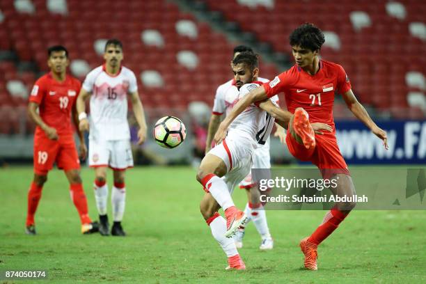 Ali Jaafar Mohamed Madan of Bahrain and Muhammad Safuwan Bin Baharudin of Singapore challenge for the ball during the 2019 Asian Cup Qualifier match...