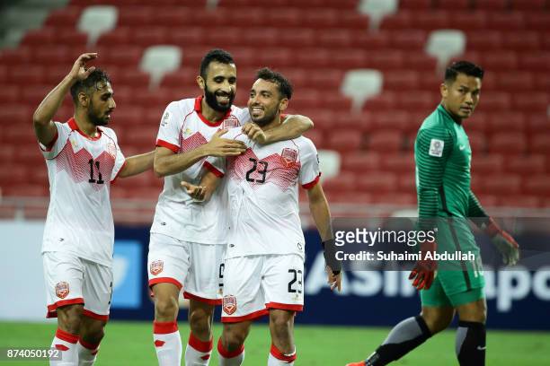 Jamal Rashed of Bahrain celebrates with teammates after scoring the second goal as Hassan Sunny of Singapore looks on during the 2019 Asian Cup...