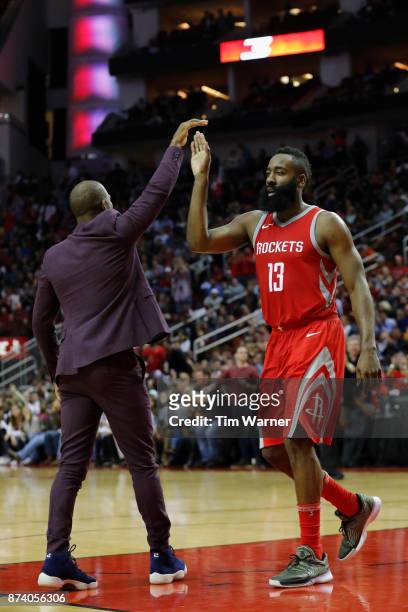 Chris Paul of the Houston Rockets greets James Harden during a time out in the second half against the Cleveland Cavaliers at Toyota Center on...