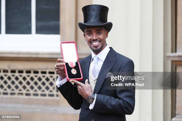 Four-time Olympic champion Sir Mo Farah poses after receiving his knighthood from Queen Elizabeth II at Buckingham Palace on November 14, 2017 in...
