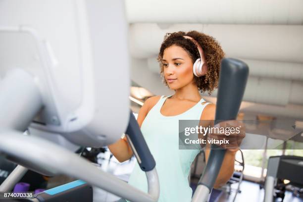 elliptical trainer cardio - happy caucasian woman on elliptical trainer at gym stock pictures, royalty-free photos & images