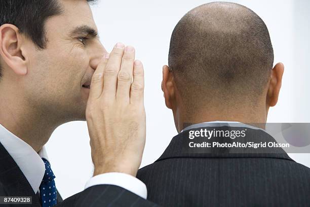 businessman whispering in colleague's ear, close-up - shaved-buzz-cut-back-of-head photos et images de collection