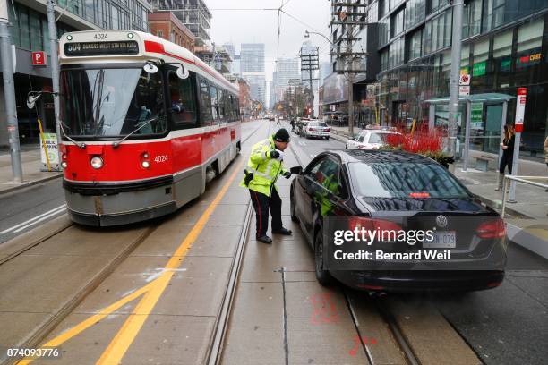 Toronto Police Services Constable Bryce Levert stops and gives drivers a warning that they can no longer drive through intersection along King St....