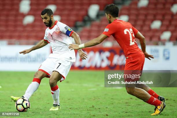 Abdulwahab Ali Alsafi of Bahrain shoots past Muhammad Zulfahmi Bin Mohd Arifin of Singapore during the 2019 Asian Cup Qualifier match between...