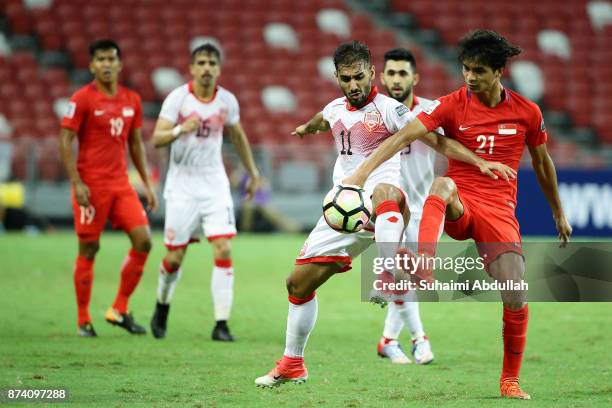 Ali Jaafar Mohamed Madan of Bahrain and Muhammad Safuwan Bin Baharudin of Singapore challenge for the ball during the 2019 Asian Cup Qualifier match...