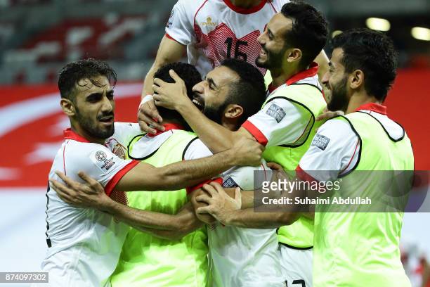 Mahdi Abdul Jabbar of Bahrain celebrates with teammates after scoring the first goal during the 2019 Asian Cup Qualifier match between Singapore and...