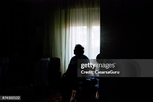 Senior Woman Alone in Dark Room Senior Woman Alone in Dark Room