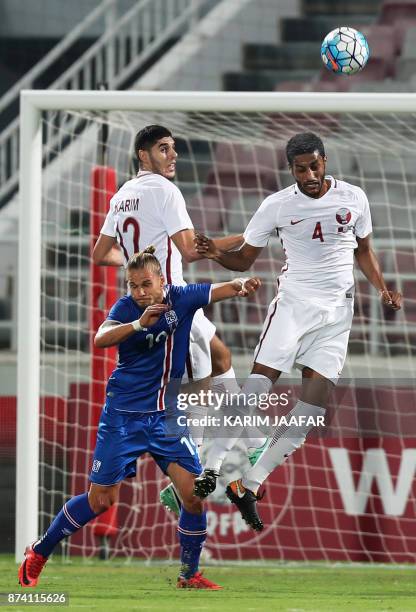 Iceland's midfielder Rurik Gislason vies for the ball against Qatar's defender Almahdi Ali Mukhtar and Karim Boudiaf during the friendly football...