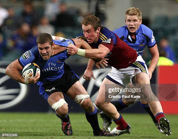 Matt Hodgson of the Force attempts to break a tackle by Jimmy Cowan of the Highlanders during the round 14 Super 14 match between the Western Force...