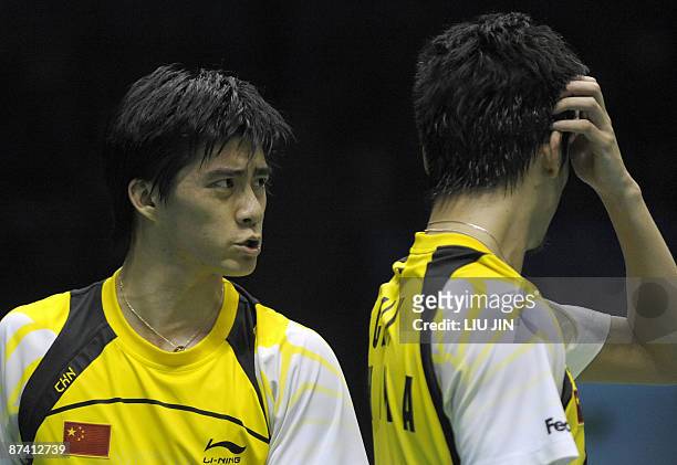 China's Fu Haifeng talks to his teammate Cai Yun during the men's doubles semifinal match against Malaysia's Koo Kean Keat and Tan Boon Heong at the...