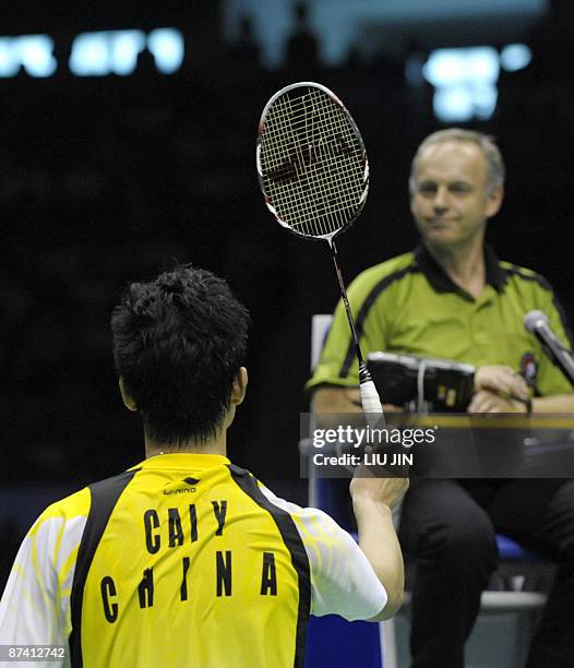 China's Cai Yun shows his broken string to an umpire during the men's doubles semifinal match against Malaysia's Koo Kean Keat and Tan Boon Heong at...