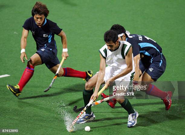 Pakistan's Shakeel Abaasi controls the ball past South Korea's You Hyo Sik as Hong Eun Seong dives for the ball during their final match at the Asia...