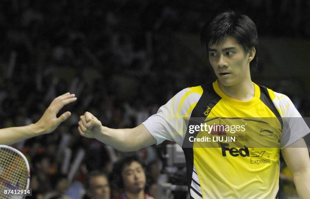 China's Fu Haifeng claps with his teammate Cai Yun during the men's doubles semifinal match against Malaysia's Koo Kean Keat and Tan Boon Heong at...