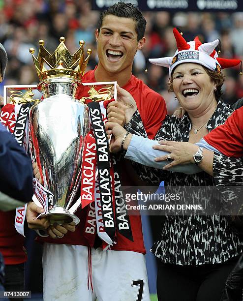 Manchester United's Portuguese midfielder Cristiano Ronaldo celebrates with his mother and the English Premier League trophy after the 0-0 draw with...