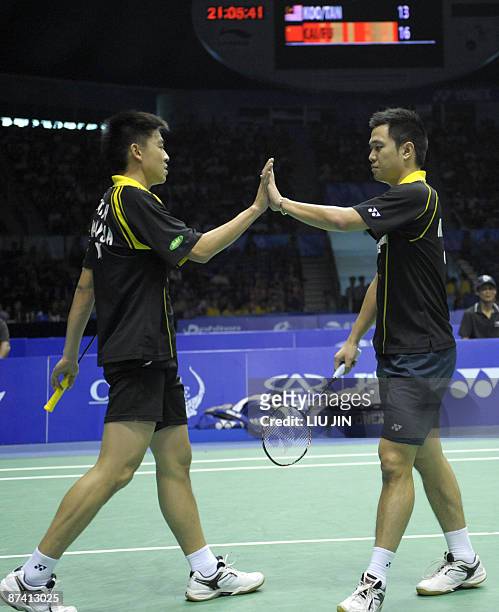 Malaysia's Koo Kean Keat claps with his teammate Tan Boon Heong during the men's doubles semifinal match against China's Fu Haifeng and Cai Yun at...