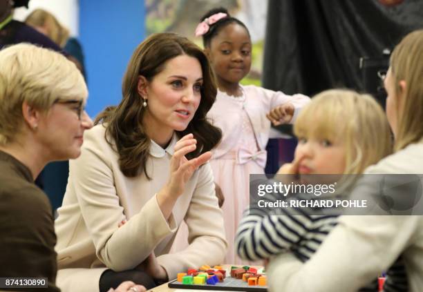 Britain's Catherine, Duchess of Cambridge chats with mothers and children during her visit to the Hornsey Road Children's Centre in north London on...