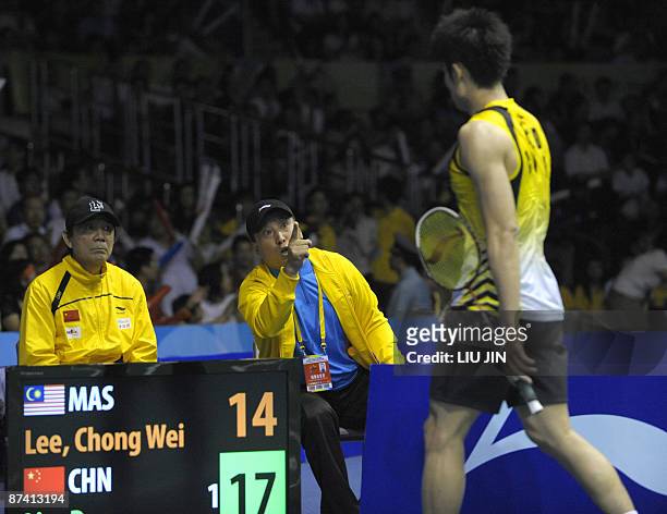 Chinese badminton team head coach Li Yongbo encourages his player Lin Dan during the men's singles semifinal match against Malaysia's Lee Chong Wei...