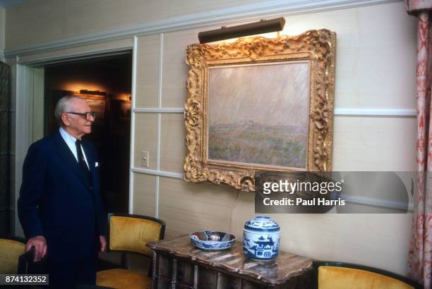 Dr Armand Hammer was an American business manager and owner, most closely associated with Occidental Petroleum, photographed at home looking at one...