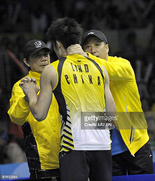 Chinese badminton team head coach Li Yongbo and coach Tang Xianhu congratulate player Lin Dan after winning over Malaysia's Lee Chong Wei during the...