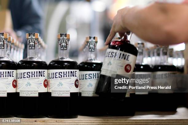 Seth Powers, a production staffer at Maine Craft Distilling, begins boxing bottles of bluberry moonshine. The company is one of several distilleries...