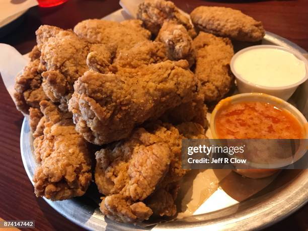 plate of buffalo chicken wings with sauce - fried chicken plate stock pictures, royalty-free photos & images