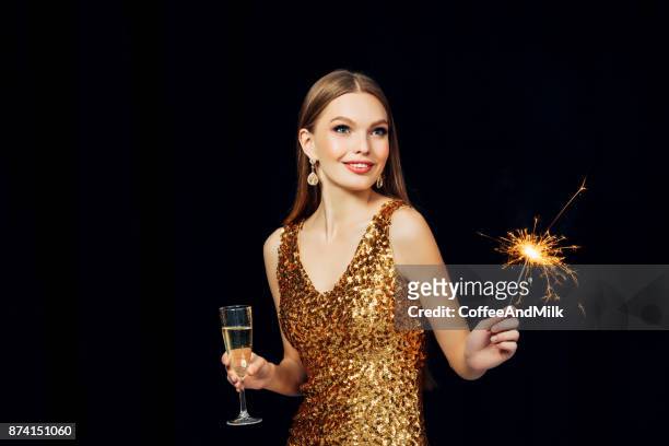 smiling girl with christmas sparkler - girl gold dress stock pictures, royalty-free photos & images