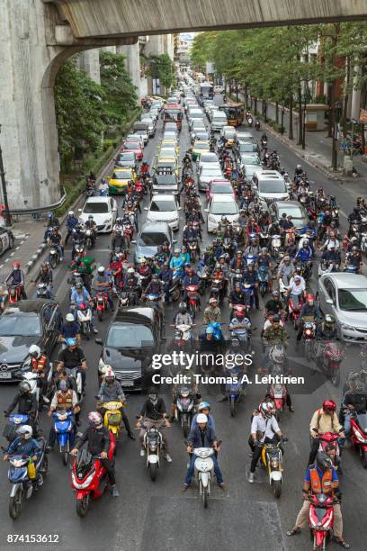 many scooters and cars on a road in bangkok - traffic jams in bangkok fotografías e imágenes de stock